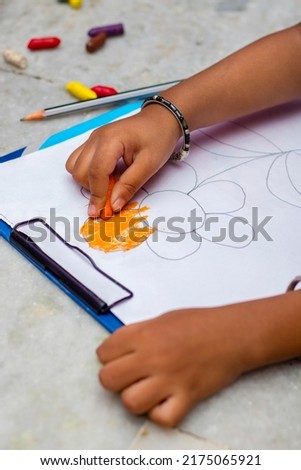 a baby boy is drawing in a classroom.