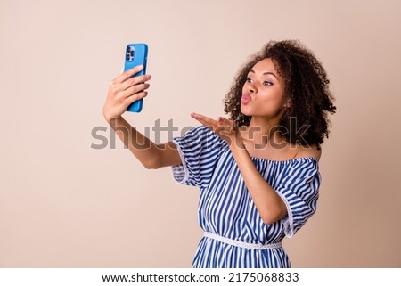 Photo of funny cute lady wear striped outfit sending kiss arm recording video modern gadget isolated beige color background