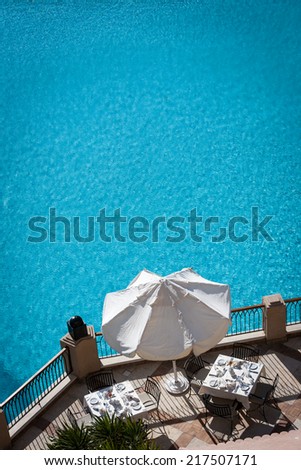Poolside dining. Tables set for dining by the pool of a luxury hotel.