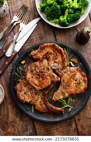 Grilled or pan fried pork chops on the bone with garlic and rosemary Royalty-Free Stock Photo #2175078835