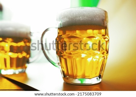 Saint Patrick's Day holiday. National Irish holiday. Green beer. Hand with a mug emerald beer in a bar.