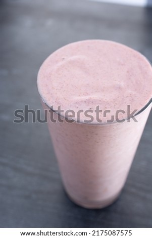 A view of a light purple red cold smoothie beverage.
