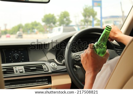 Man drinking beer while driving a car Don't drink and drive concept. 