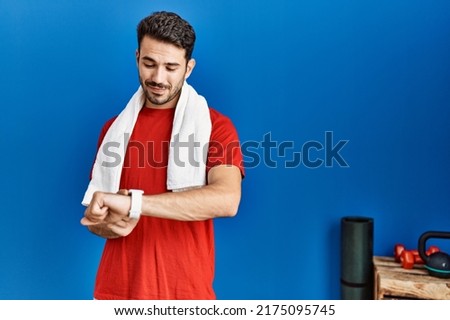 Young hispanic man wearing sportswear looking stopwatch at sport center Royalty-Free Stock Photo #2175095745