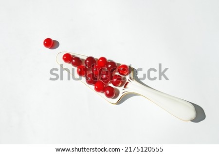 Fruity minimalist concept of cherries on a pie spatula on a white background with space for text