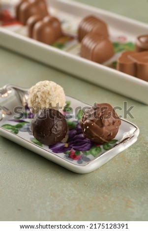 Dark brown, light brown and white chocolates in the plate. Delicious chocolates. Close-up picture of round chocolate. Selectively focused on the chocolate. Concept picture. 