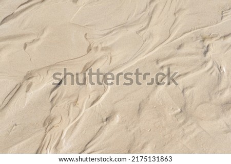 Above view of beach sand with wind swept patterns from gust winds with copy space. Closeup of detail and texture background with copyspace of erosion from climate change and global warming on land