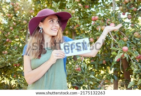 One happy woman holding open sign to advertise apple picking season on sustainable orchard farm outside on a sunny day. Cheerful farmer pointing to trees for harvesting juicy nutritious organic fruit