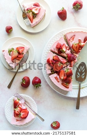 Top down view of servings of homemade strawberry cheesecake. Royalty-Free Stock Photo #2175137581