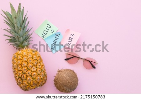 Pineapple and coconut and sunglasses on a bright pink background. Hello summer concept