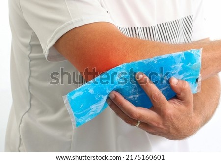 Injured Man using reusable ice gel packs his elbow, medical first aid after accident. Man pain elbow with color Enhanced skin with red spot indicating location of the pain isolated on white. 