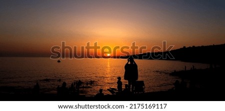 Girl taking a picture of the sunset 