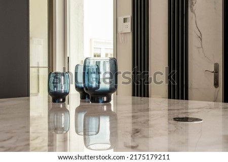 Decorative blue glass vases on white marble top where they are reflected