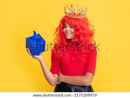child smile in queen crown with present box on yellow background