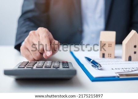 man using calculator during signing home contract documents. Contract agreement, real estate,  buy and sale and insurance concepts