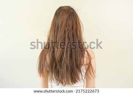 Damaged hair, frustrated asian young woman, girl in splitting ends, messy unbrushed dry hair and frizzy with long disheveled hair, health care of beauty. Portrait isolated on background, Back view. Royalty-Free Stock Photo #2175222673