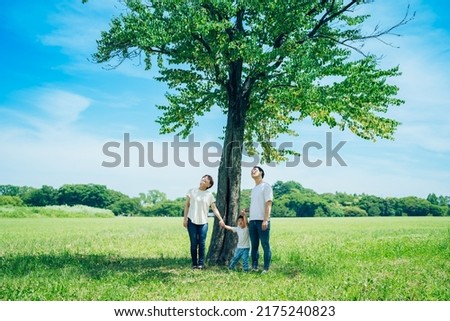 parents and their child lined up under a tree Royalty-Free Stock Photo #2175240823