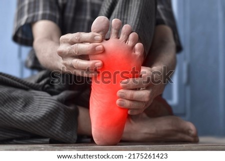 Tingling and burning sensation in foot of Asian old man with diabetes. Foot pain. Sensory neuropathy problems. Foot nerves problems. Plantar fasciitis. Royalty-Free Stock Photo #2175261423