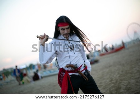 long-haired boy with vampire pirate costume and sword. High quality photo