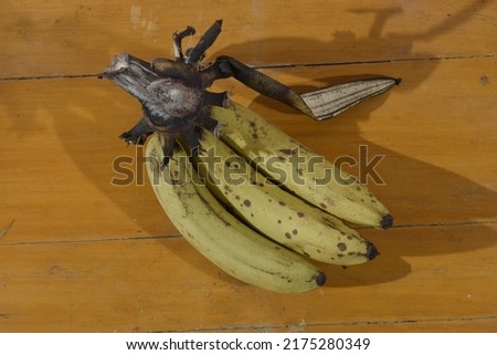 three ripe bananas on a wooden table