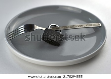 a fork with a lock on a gray plate concept diet. High quality photo