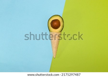 avocado ice cream, ice cream cone with a slice of avocado on a pastel green-blue background, creative modern summer design