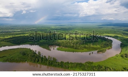 Flooded river floodplain with field and forest in wild lanscape. High altitude wide drone shot flooded area at spring time cloudy day Royalty-Free Stock Photo #2175327311