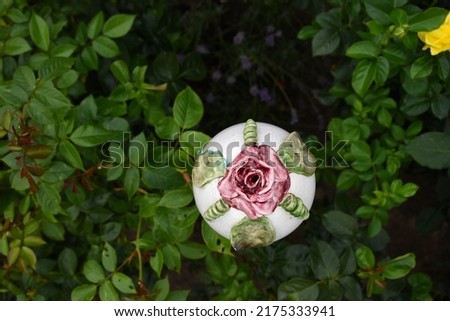Garden orb for insect housing with beautiful red rose, insect hotel for earwigs, view from top