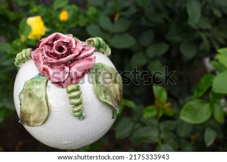 Garden orb for insect housing with beautiful red rose, insect hotel for earwigs