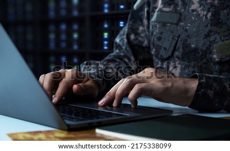 Surveillance and control of opposing information concept, Soldier in camouflage uniform working on laptop for Information Operation. Royalty-Free Stock Photo #2175338099