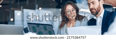 Close up of smiling businessmen discussing documents with graphs and charts in a modern office. Royalty-Free Stock Photo #2175384757