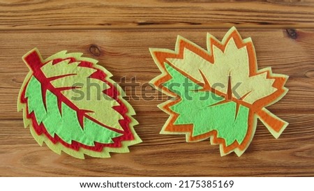 Decorative autumn leaves on a wooden table. The leaves are made from felt. DIY. 