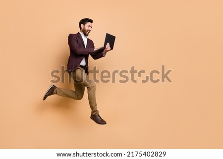 Full length profile side photo of hardworking businessman do paperwork online isolated on beige color background