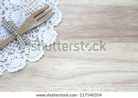 picture of fork, doily with wood background