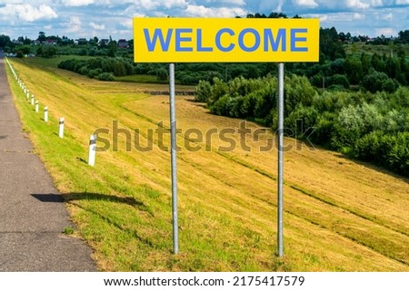 Welcome yellow road sign on natural landscape background
