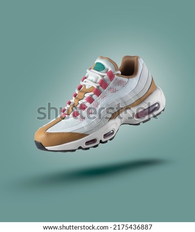 White sneaker with colored accents on a green gradient background, fashion, sport shoe,  air, sneakers, lifestyle, concept, product photo, levitation concept, street wear, trainer Royalty-Free Stock Photo #2175436887