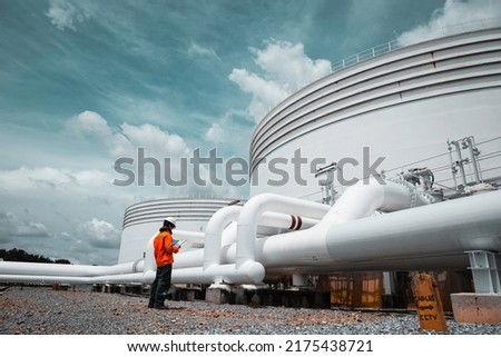 Male worker inspection at steel long pipes and pipe elbow in station oil factory during refinery valve of visual check record pipeline tank oil and gas industry Royalty-Free Stock Photo #2175438721