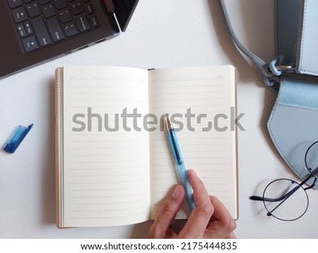 blank agenda book.  equipped with a laptop, bag, glasses, pen.  isolated background in white.  flat lay photography.  working time concept