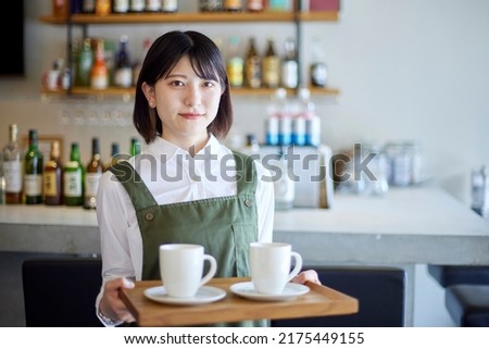 Young Japanese woman working in a cafe Royalty-Free Stock Photo #2175449155