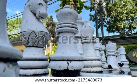 Outdoor chess board with big stone pieces located at garden area