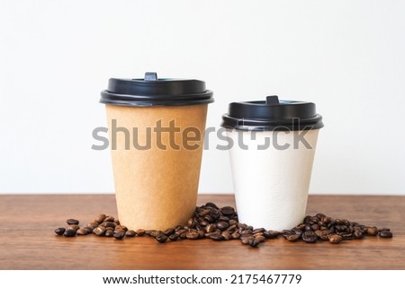 Coffee paper cup on wooden table. Mockup for you designs.