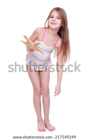 attractive little girl wearing pink swimsuit holding big sea star isolated
