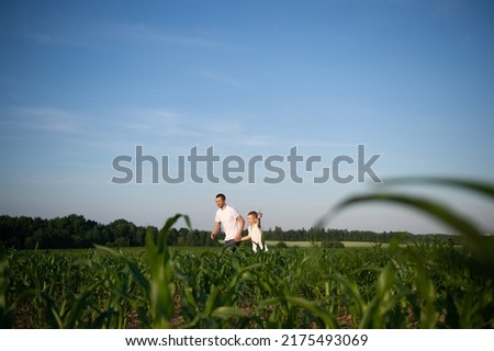 Cute boy in a cornfield with dad launching a plane