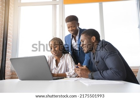 team of african successful people behind a laptop