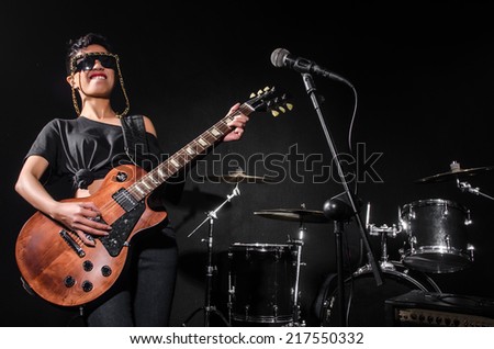 Young woman playing guitar during the concert