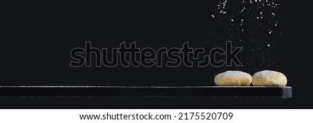Horizontal banner of freshly cooked yeast dough on a wooden board on a black background.