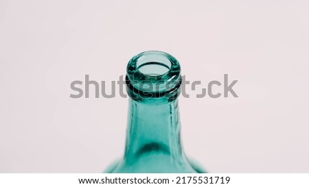 Glass transparent green bottle for liquids without the cap on a white background.