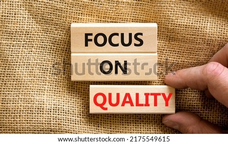 Focus on quality symbol. Concept words Focus on quality on blocks on beautiful canvas table canvas background. Businessman hand. Business, focus on quality concept. Copy space.