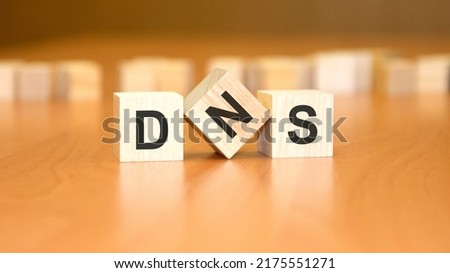 DNS text on wooden blocks, financial business concept, brown background