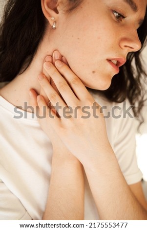 Sick attractive girl touches throat with pain. Laryngitis first symptoms throat ache. Seasonal illness medecine Royalty-Free Stock Photo #2175553477